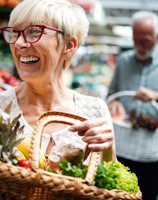 woman with basket of fresh produce from farmers market